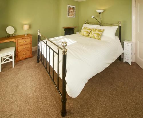 a bedroom with a large bed with white sheets and yellow pillows at The Castle House in Whitby