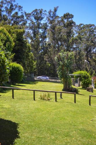 a wooden fence in a park with trees at La Casa de Liber in Tandil