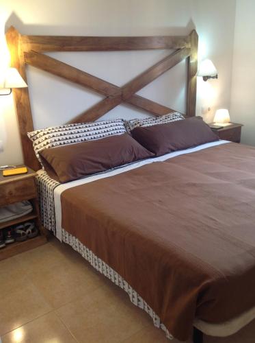 コラレホにあるCasa Ilaria Fuerteventura -Wifi freeのベッドルーム1室(大型ベッド1台、木製ヘッドボード付)