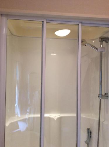 a glass shower door in a bathroom at Tarka holiday park, 5A in Barnstaple