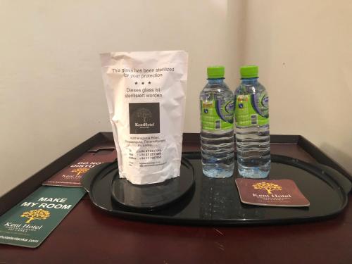 two bottles of water and a bag on a tray at The Kent in Tissamaharama
