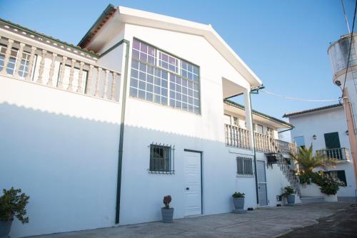 a white house with a garage at Residencial Cabeça da Velha in Catraia do Bugalho