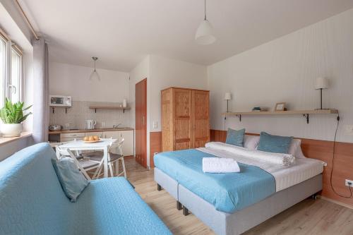 a bedroom with a bed and a table and a kitchen at Szymonówka W Szklarskiej Porębie in Szklarska Poręba