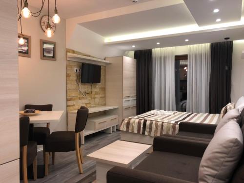 a bedroom with a bed and a dining room at Milmari Resort in Kopaonik