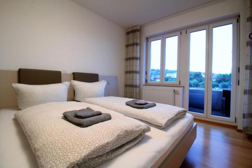 ein Schlafzimmer mit 2 Betten und Handtüchern darauf in der Unterkunft Luxury city apartment - view of river and castle in Würzburg