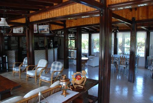 a living room with wooden ceilings and tables and chairs at Diaporos Hotel in Vourvourou