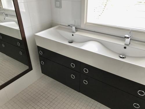 a bathroom with a large sink and a mirror at Merenranta Huvila 210 m2 in Kokkola