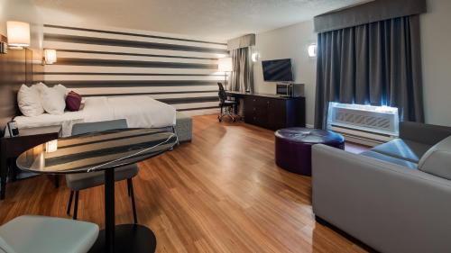a hotel room with a bed and a couch at Hôtel Albert par G5 in Rouyn