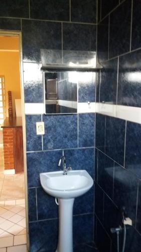 baño con lavabo y pared de azulejos azules en Casa da Mary, en Pirenópolis