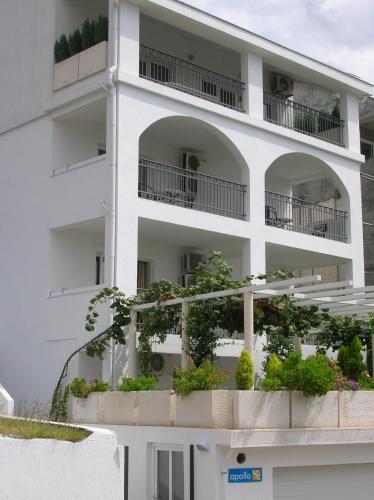 a white apartment building with plants on the balconies at Villa Mila in Petrovac na Moru