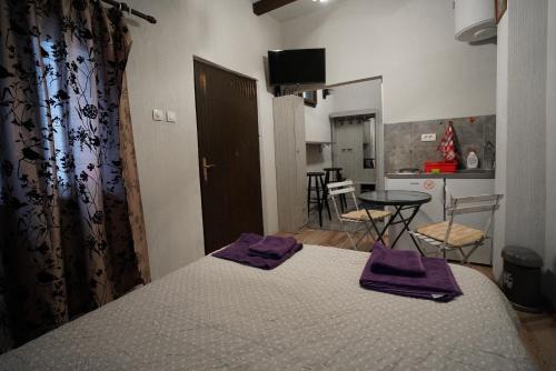 ein Schlafzimmer mit einem Bett mit lila Handtüchern darauf in der Unterkunft Apartman Rale in Belgrad