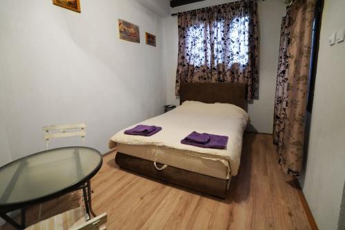 Dormitorio pequeño con cama y mesa de cristal en Apartman Rale, en Belgrado