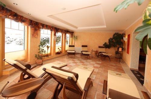 a room with chairs and tables and windows at Aparthotel DAS Hochkönig in Ramsau am Dachstein