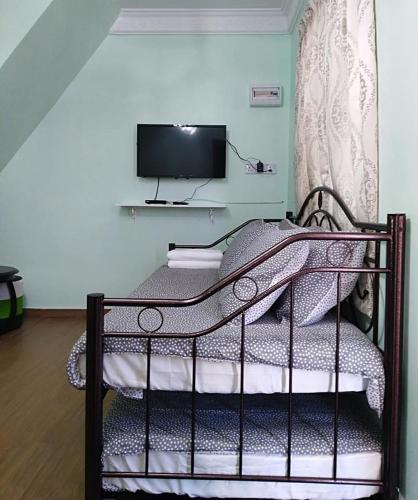 a bedroom with a bed with a tv on the wall at M's Place Chalet Bed&Breakfast in George Town
