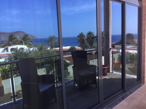 a balcony with two chairs and a view of the ocean at Lali's House in Tarrafal