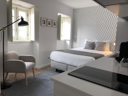 a bedroom with a bed and a desk with a laptop at São Bento na Alta in Coimbra