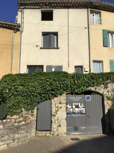 a building with an ivy covered wall and a door at L ANNEXE in Malaucène