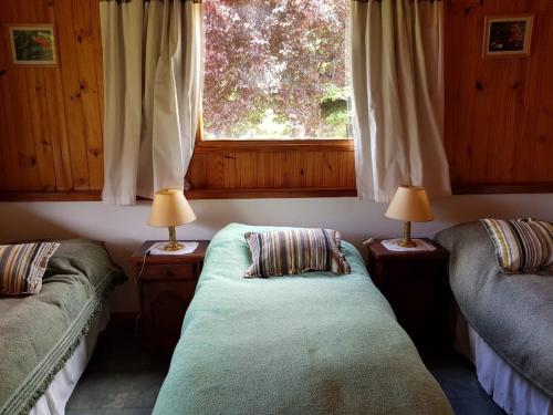 a living room with two beds and a window at Nahuel Mapi Lodge in Pilolil