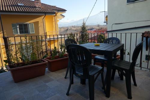 un tavolo nero e sedie sul balcone di il Loft a Cuneo