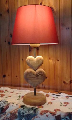 a lamp with a heart shaped chair sitting on a bed at Sella Ronda Apartment in Campitello di Fassa