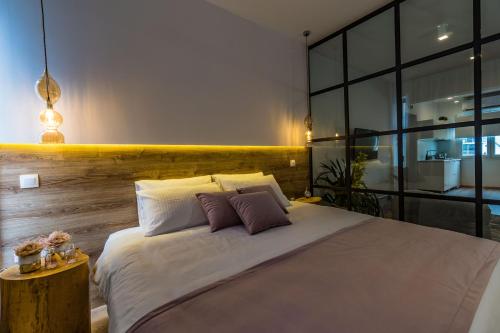 a bedroom with a large white bed with two pillows at Glossy Lodge in Thessaloniki