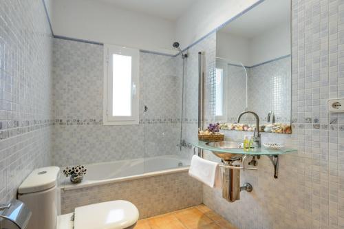 a bathroom with a tub and a sink and a toilet at Villa Can Ameler in Sant Carles de Peralta