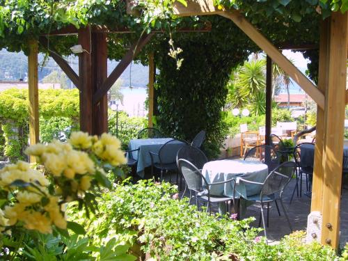 a patio with tables and chairs under a pergola at Hotel Danila in Portoferraio