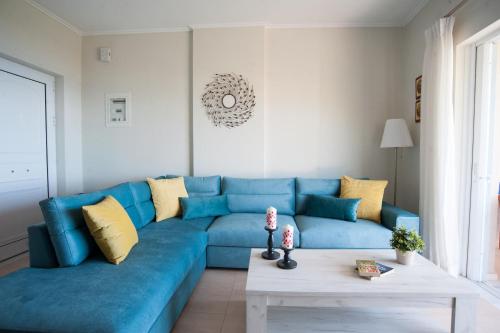 a blue couch in a living room with a table at Nicopolis Villa in Vráchos