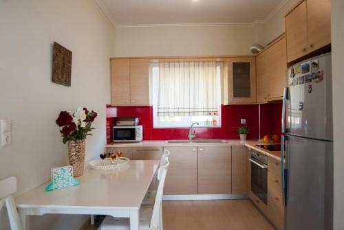 Il comprend une cuisine équipée d'une table blanche et d'un réfrigérateur. dans l'établissement Nicopolis Villa, à Vráchos