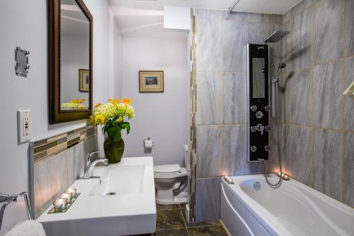 a bathroom with a tub and a sink and a toilet at Heartwood Inn in Drumheller