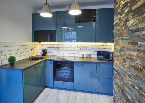 ソルトバーン・バイ・ザ・シーにあるHost & Stay - Pearl Apartmentの青いキャビネットとレンガの壁が備わるキッチン