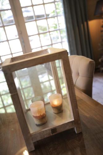 two candles in a glass case on a table at Lindenhof in Garderen