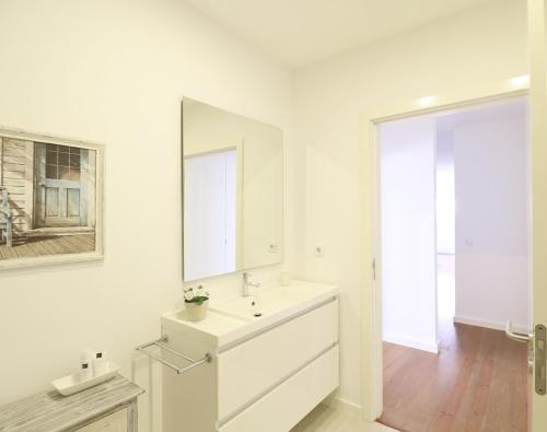 リスボンにあるDowntown Charming Apartmentの白いバスルーム(シンク、鏡付)