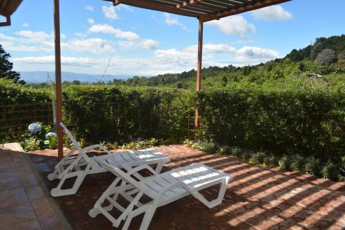 two white lawn chairs sitting under an umbrella at Finca Paraiso Mountain Retreat near San Jose Airport in Birrí