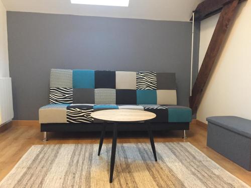 a living room with a couch and a table at Gîtes d'Olbiche in Avranches