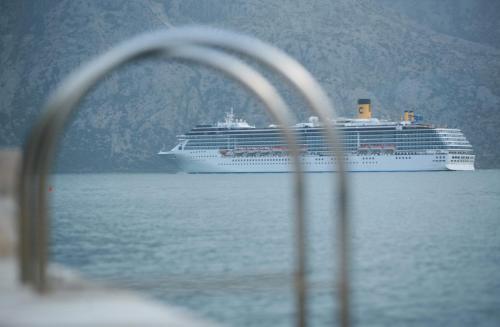 a cruise ship in the water with a mountain at Hotel Galathea in Kotor