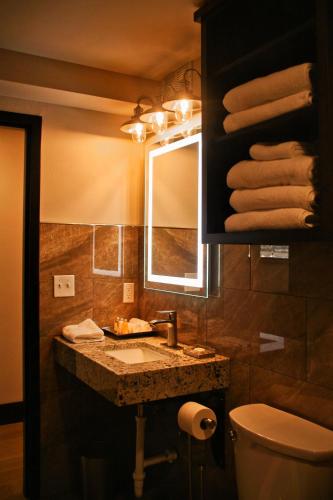 a bathroom with a sink and a mirror and towels at Iron Springs Luxury Lodge & Spa in Cedar City