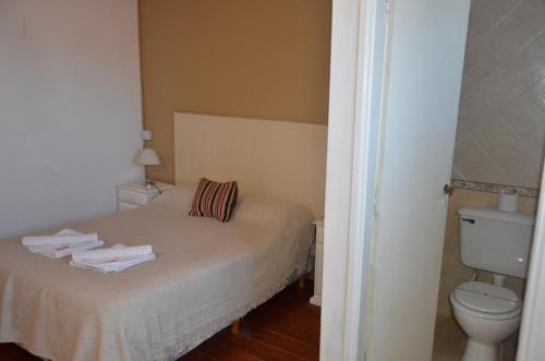 a small bedroom with a bed and a toilet at Kumen Apart de Playa in San Bernardo