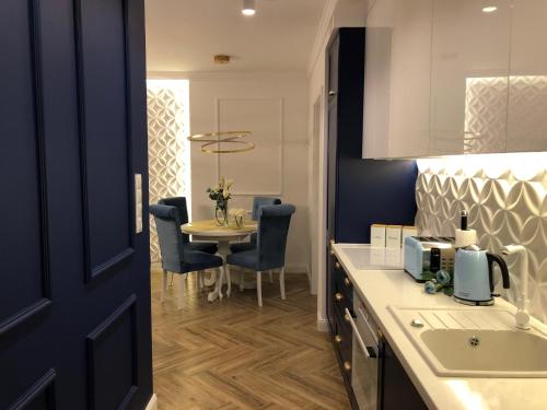 a kitchen with a table and a dining room at Family & Business Sauna Apartments No2 Leśny nad Zalewem Cedzyna - 2 Bedroom with Private Sauna, Bath with Hydromassage, Terrace, Parking, Catering Options in Kielce