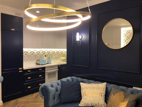 a living room with a blue couch and a large chandelier at Family & Business Sauna Apartments No2 Leśny nad Zalewem Cedzyna - 2 Bedroom with Private Sauna, Bath with Hydromassage, Terrace, Parking, Catering Options in Kielce