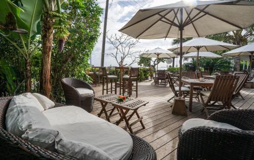 an outdoor patio with chairs and tables and umbrellas at Seaview Lodge and Restaurant in Nuku‘alofa