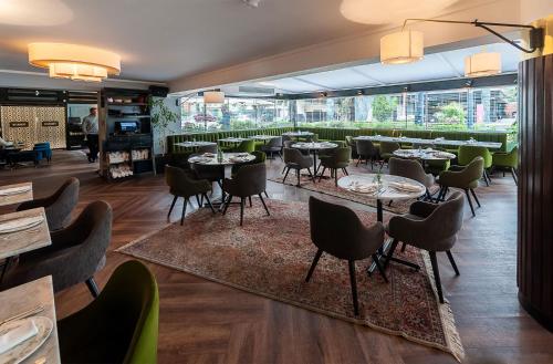 um restaurante com mesas e cadeiras num quarto em Roosevelt Hotel & Suites em Lima