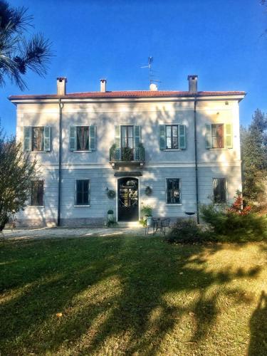 a large white house with a lawn in front of it at Villa Manto in Mantova