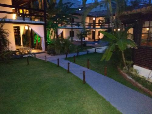 a courtyard of a house at night with a lawn at Pousada Solar de Itaúna in Saquarema