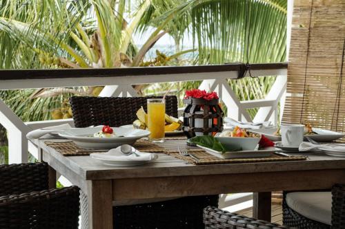 Seaview Lodge and Restaurant في نوكو ألوفا: طاولة خشبية عليها صحون طعام
