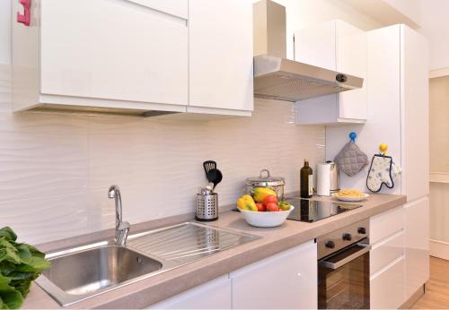 a kitchen with a sink and a bowl of fruit at Fidanza House in Bagnoregio