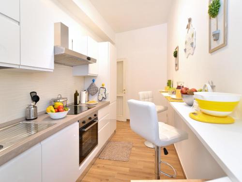 a kitchen with white cabinets and a yellow bowl on the counter at Fidanza House in Bagnoregio