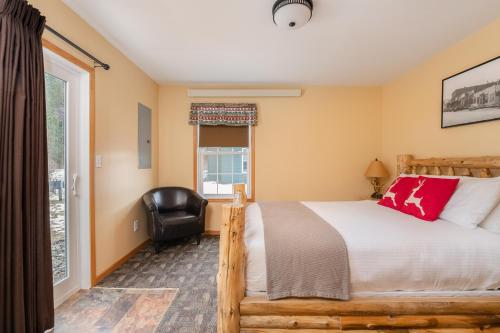 a bedroom with a bed and a chair and a window at Black Elk Resort in Hill City