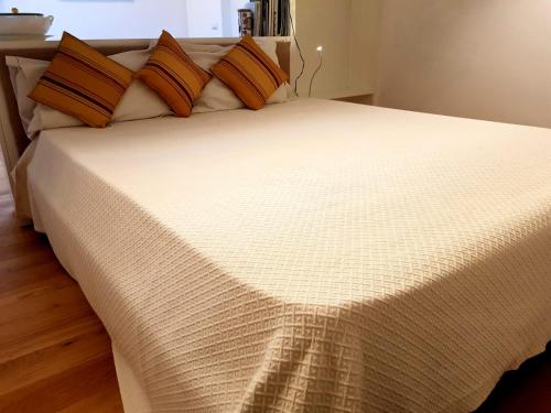 a bed with orange and white sheets and pillows at Loft Bianco in Florence
