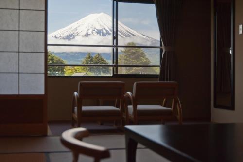 a room with a view of a mountain through a window at Oike Hotel in Fujikawaguchiko